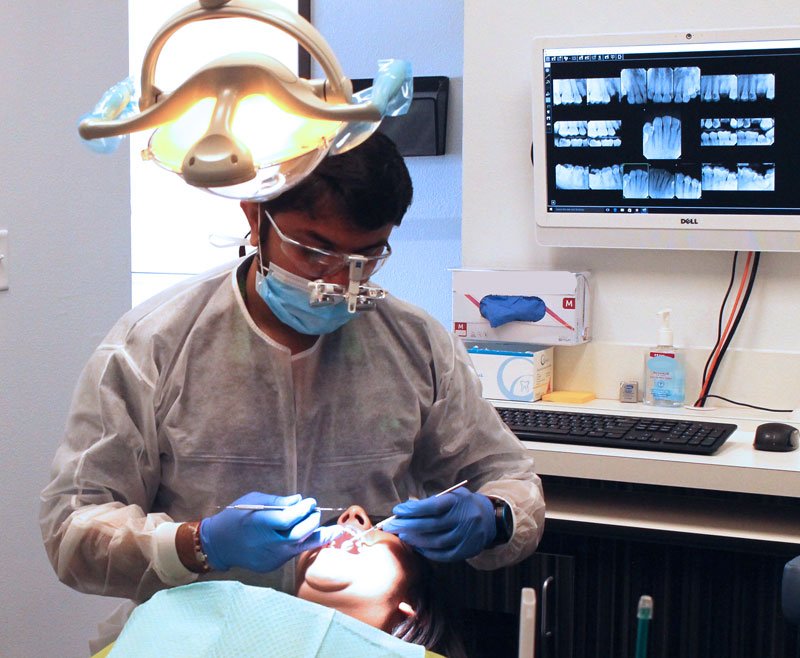 Dentist holding a dental implant model during a patient consultation